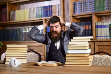 Man in classic suit or professor with mad face sits