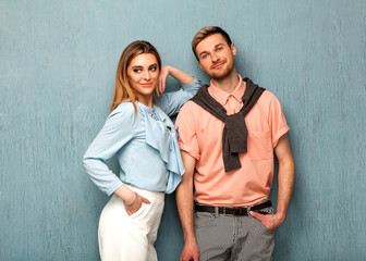 Fashion girl and guy in outlet clothes posing on a blue background. Valentines Day.
