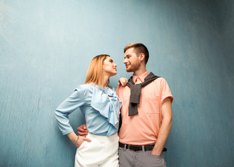 Fashion girl and guy in outlet clothes posing on a blue background