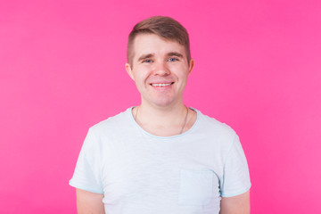 Handsome smiling young man on pink background