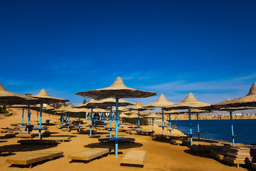 Fototapeta na wymiar Straw umbrellas on beautiful sunny beach