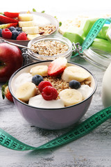 muesli with dairy and fruit, healthy lifestyle. bowl of cereal, fruit and dumbbell