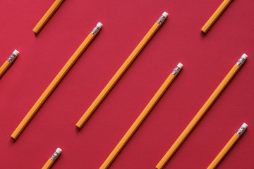 Yellow wooden pencil on red background - Education background concept with a bunch of yellow wooden...