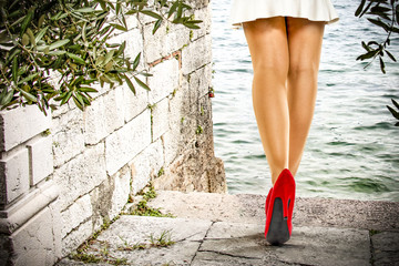 slim woman legs and red heels 