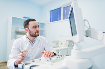 Male doctor with ultrasonic equipment during ultrasound medical examination