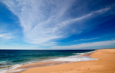 Beach under cirrus clouds at the Todos Santos artist community in central Baja California Mexico BCS