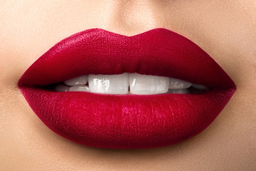 Close up view of beautiful woman lips with red matt lipstick
