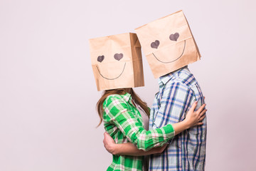 Valentine's day concept - Young love couple with bags over heads on white background