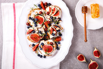 Bruschetta with cheese, figs , thyme and berry blueberrie with honey.Snack a sandwich with cream cheese.selective focus