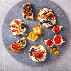 Bruschetta with cheese, figs , thyme and berry blueberrie with honey.Snack a sandwich with cream cheese.selective focus