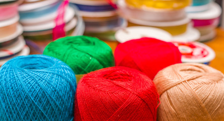 Close up of colorful wool yarn balls in a blurred background