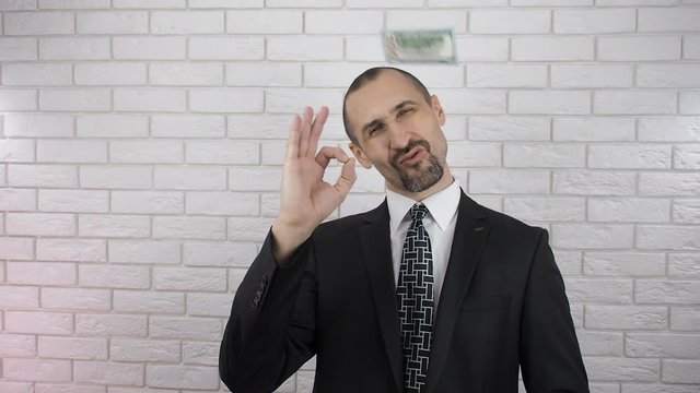 Businessman shows gesture perfectly. A man in a suit is flying money.