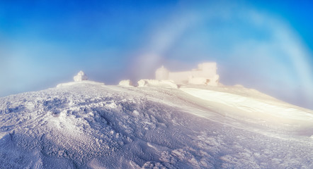 Amazing phenomenon - rainbow in winter snow mountains. Breathtaking panorama of old desolate...