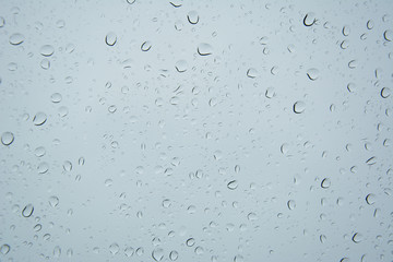 Tropfen auf einer Fensterscheibe mit blauem Hintergrund