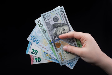 Hand holding American dollar  isolated on black background