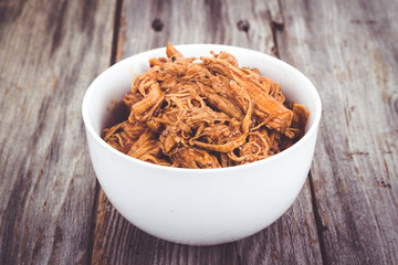bbq pulled pork bowl over a wooden plank table