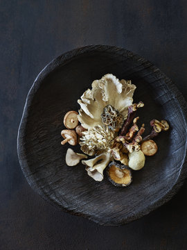 Wooden bowl of various mushrooms
