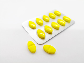 Medication and healthcare concept. Many yellow pills of  paracetamol 450 mg combined with orphenadrine 35 mg . isolated on white background, used to treat injuries and painful muscular conditions.