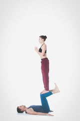 Young athletic couple practicing acroyoga. Balancing in pair