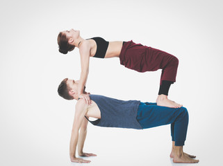 Naklejka premium Young athletic couple practicing acroyoga. Balancing in pair