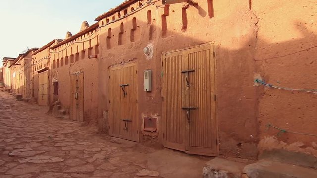 Personal view of walking in desert scenic city Ait-Ben-Haddou Castle in Morocco, exterior in movie Game of Thrones, Steady cam shot