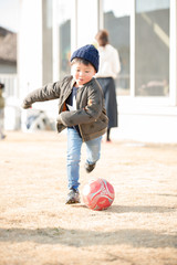 庭でサッカーをする子供