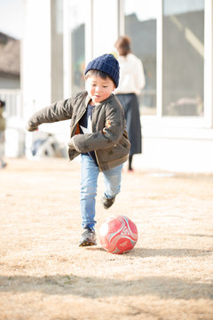 庭でサッカーをする子供