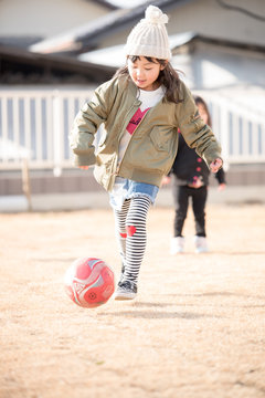 庭でサッカーをする女の子