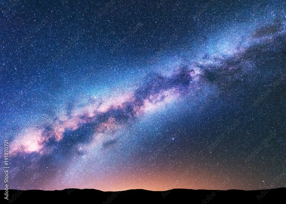 Wall mural milky way. fantastic night landscape with purple milky way, sky full of stars, yellow light and hill