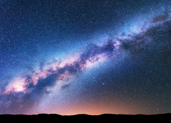 Milky Way. Fantastic night landscape with purple milky way, sky full of stars, yellow light and...