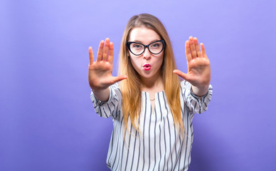 Young woman making a rejection pose on a solid background