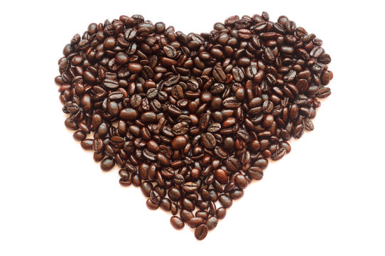 Roasted coffee beans in half heart shape on white background, isolated picture