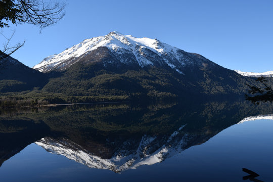 Splendid and calm day in Lake Traful, Patagonia Argentina. Beautiful landscape with mountains reflected in the lake on a sunny day.