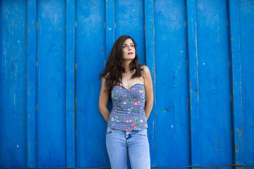 Fototapeta na wymiar Portrait of beautiful girl in urban blue background