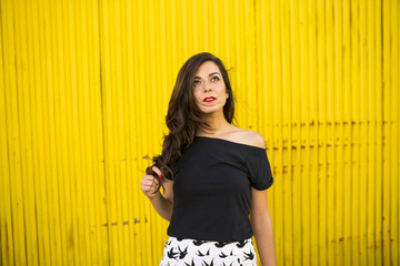 Fototapeta premium Portrait of beautiful girl in urban yellow background