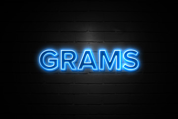Obraz premium Grams neon Sign on brickwall