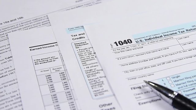 Tax form 1040 and pen on the desk. dolly shot