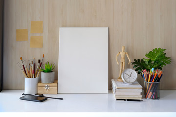 Mockup workspace and poster and artist craft accessories on desk.