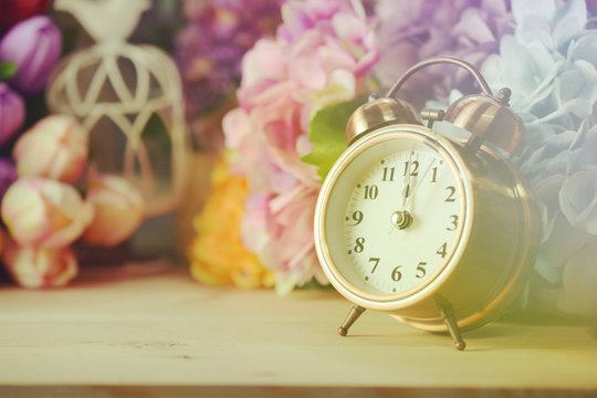 alarm clock and artificial flowers bouquet with filter color