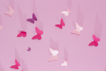 Paper butterflies on a pink background. Love and Valentine's day concept. Top view