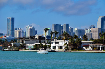 View of the florida intra-coastal waterway,houses on Riva Alta an upscale island community on Miami Beach and downtown Miami commercial and residential towers skyline.