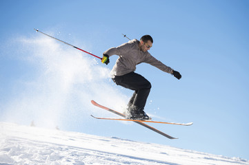 Fototapeta na wymiar Freestyle ski jumper with crossed skis in snowy mountains