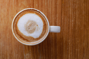 Hot coffee with latte art on table in coffee shop for background or cafe menu design