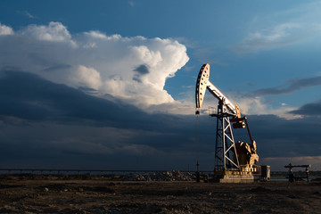 View of oil field against cloudy sky