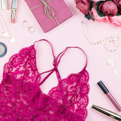Woman fashion accessories, make up products and red lingerie on pastel background.