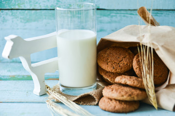 fresh oatmeal cookies with milk on wooden background