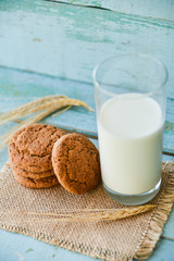 fresh oatmeal cookies with milk on wooden background