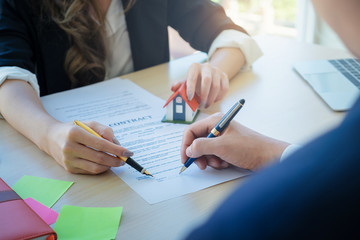 Close up of agency pointing and signing agreement for buying house. Bank manager, real estate, insurance concept.