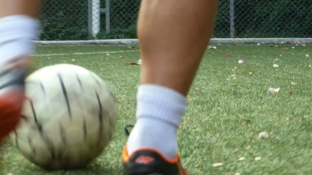 Close up,The footballer is dribbling in the grass.Football is a popular sport of people around the world.
