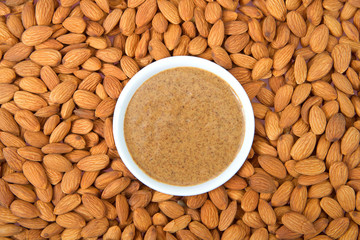 White bowl with fresh almond butter surrounded by almonod nuts. Almonds are California's third-leading agricultural product in the United States.